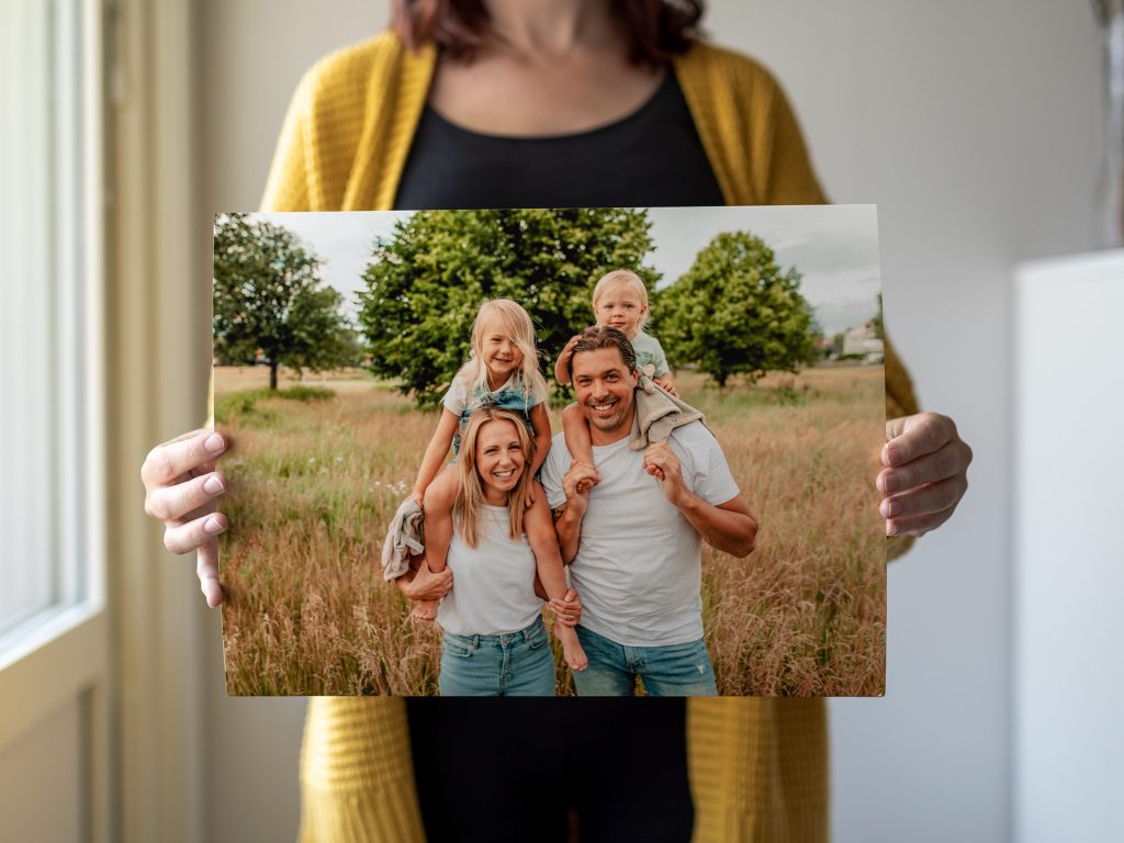 En kvinna håller i ett framkallat familjefoto.