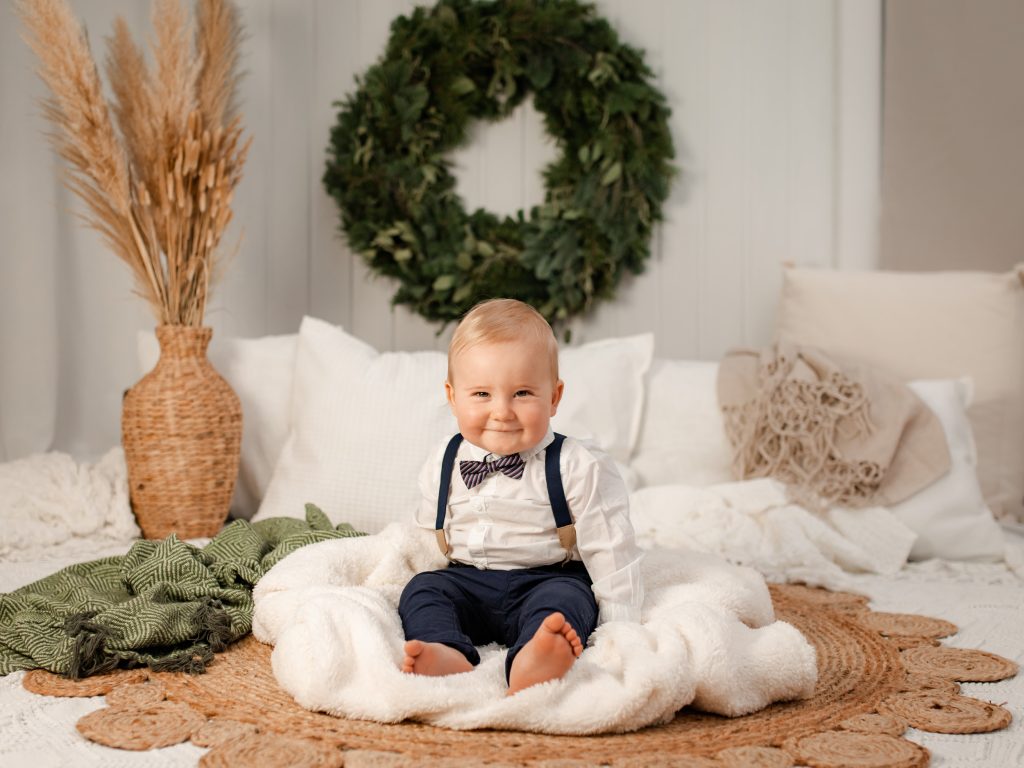 Ettåring sitter på en filt på en julkortsfotografering i Eksjö.