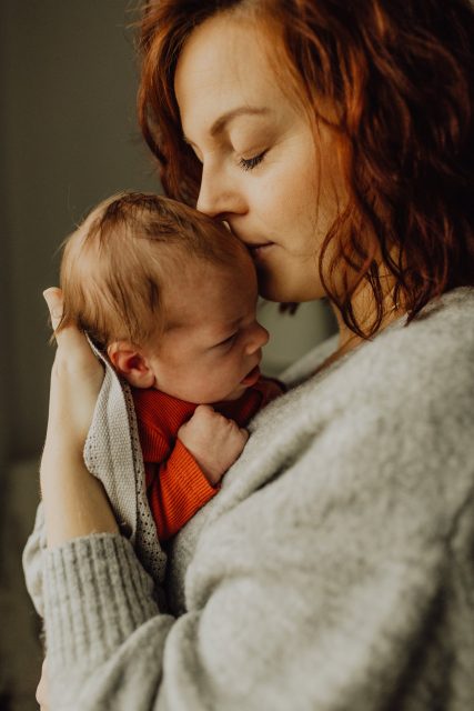 Bild på en mamma som håller sin nyfödda bebis